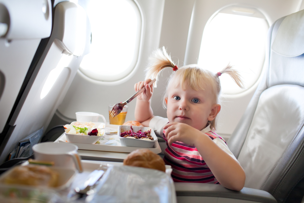 small girl eating in the airplane